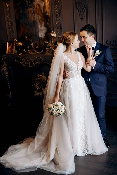 Genç bir çift karanlık bir stüdyoda, bir ayna ve bir avizeyle.