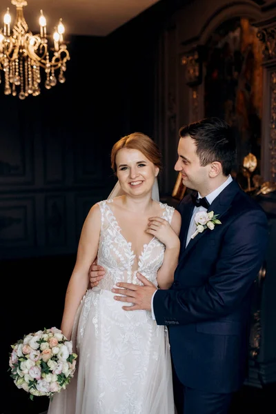 Genç bir çift karanlık bir stüdyoda, bir ayna ve bir avizeyle.