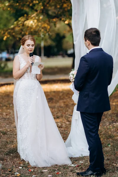 Bir adamla bir kızın düğün seremonisi Orman yolunda bir kemerin arka planına karşı