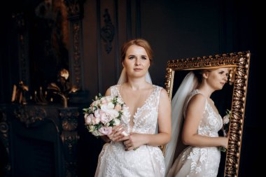 Gelin lavanta renkli pofuduk gelinlik içinde parlak bir stüdyoda buketle