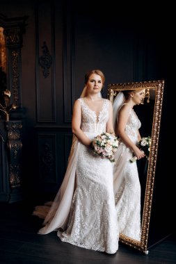 Gelin lavanta renkli pofuduk gelinlik içinde parlak bir stüdyoda buketle