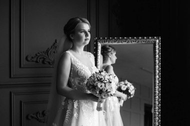 Gelin lavanta renkli pofuduk gelinlik içinde parlak bir stüdyoda buketle