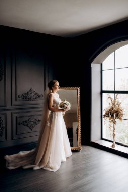 Gelin lavanta renkli pofuduk gelinlik içinde parlak bir stüdyoda buketle