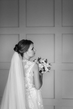 Gelin lavanta renkli pofuduk gelinlik içinde parlak bir stüdyoda buketle