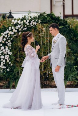 wedding ceremony of the newlyweds on the glade near the restaurant