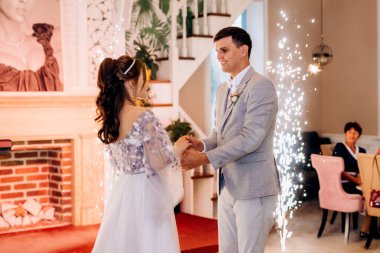 the first dance of the bride and groom inside a restaurant with heavy smoke