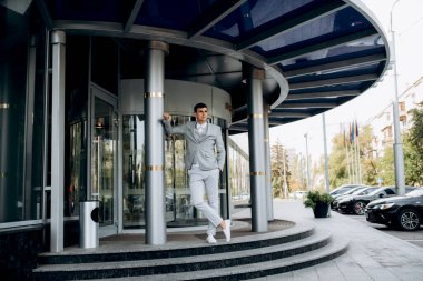 Bir otelin girişinde takım elbiseli ve beyaz papyonlu bir damadın portresi.