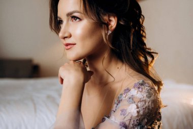 Sabahleyin bir otelde lavantalı gelinlik giymiş bir gelinin portresi.