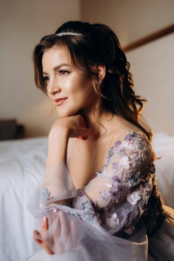 Sabahleyin bir otelde lavantalı gelinlik giymiş bir gelinin portresi.