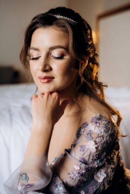 Sabahleyin bir otelde lavantalı gelinlik giymiş bir gelinin portresi.