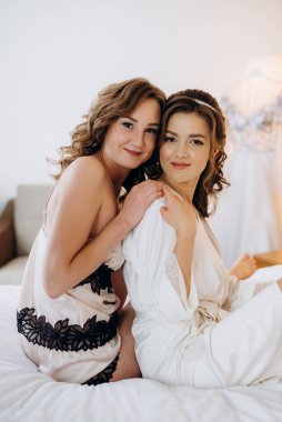 Gelin ve nedimesi düğün sabahı bir otel odasında hazırlanıyorlar.