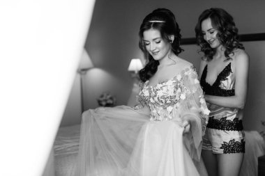 Gelin ve nedimesi düğün sabahı bir otel odasında hazırlanıyorlar.