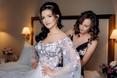 Gelin ve nedimesi düğün sabahı bir otel odasında hazırlanıyorlar.