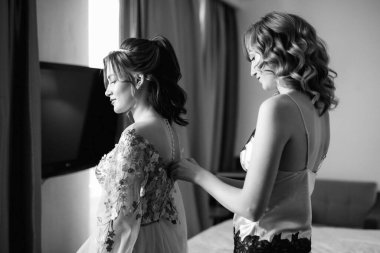 Gelin ve nedimesi düğün sabahı bir otel odasında hazırlanıyorlar.