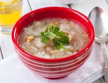 Kırmızı kasede taze deniz ürünleri çorbası.