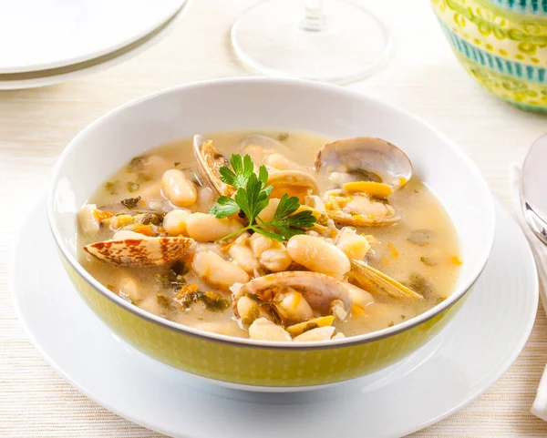 Fasulye ile servis edilen deniz ürünleri çorbası.