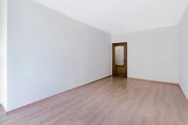 Порожня світла біла кімната з дерев'яною підлогою та скляними дверима — стокове фото