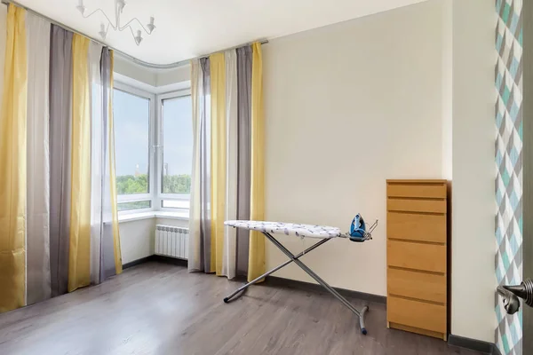 Geniş pencere çizgili perde ve demir ile ütü tahtası ile yarar odası iç kapalı modern daire iç