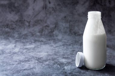 Bağışıklık güçlendirici özelliği olan fermente edilmiş kefir şişesi. Karanlık arka plan.