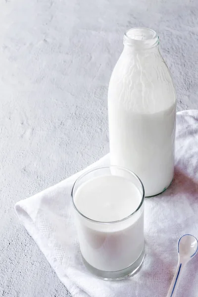 Fermente edilmiş kefir şişesi ve bağışıklık güçlendirici özellikleri olan cam kopyalama alanı olan beyaz gri arka plan.