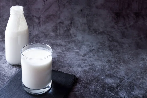 Fermented drink yogurt kefir bottle and glass with immune boosting properties dark background with copy space — Stock Photo, Image