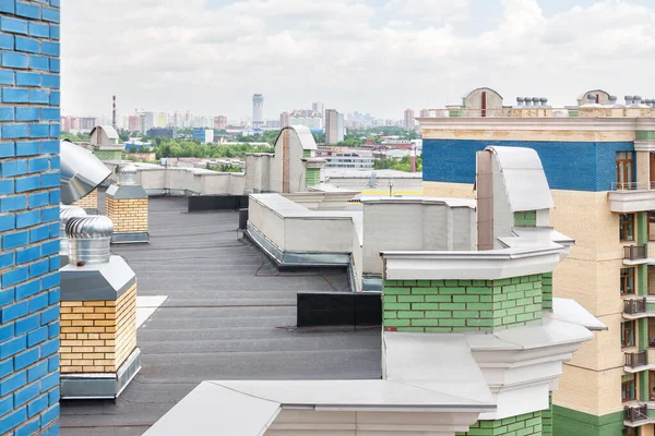 Flat roof with air conditioners on top modern apartment building exterior mixed-use urban multi-family residential district area overcast background.