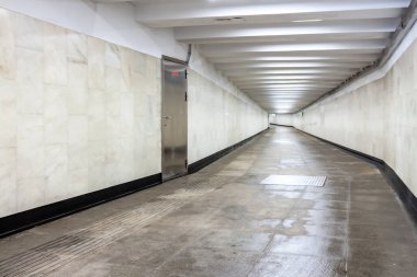 Rutubetli kiremitli bir blok ve beton tünel kentsel veya şehir yaya alt geçidi beyaz duvar ve ışık tavanlı bir manzara.