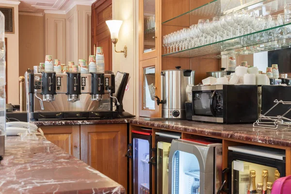 Close-up of empty vintage marble restaurant bar counter with coffee machine, microwave oven, glasses shelf