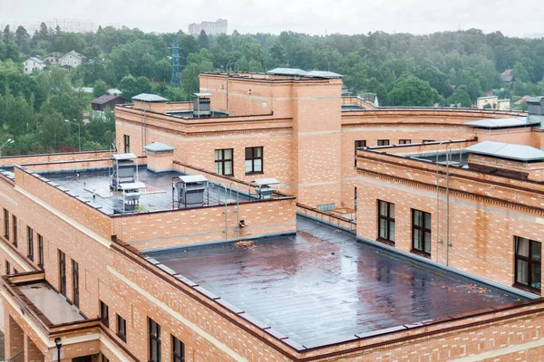 Modern apartman binasının yağmurlu günlerinde klimalı, düz ve nemli bir çatı. Satılık yeni yerleşim yerleri. Kentsel gelişim konsepti resmi
