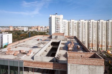 İnşaat alanının altındaki, güneşli şehir manzaralı, yüksek katlı tamamlanmamış bina. COVID-19 salgını için kapalı inşaat şirketleri