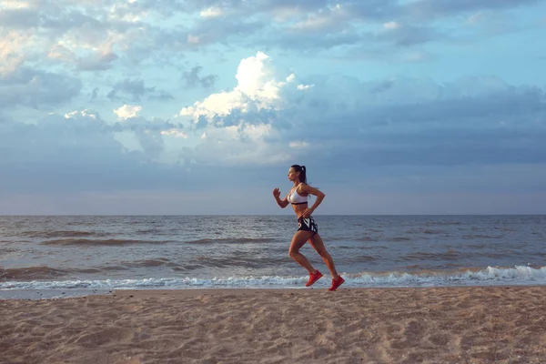 健康青年健身女人径赛跑者在日出海边上运行 — 图库照片
