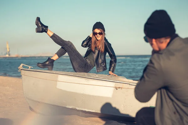 Junges verliebtes Paar spaziert am Meer entlang. Frühling, Herbst. Der Typ trägt Jacke und Hut. Mädchen mit Hut und Lederjacke mit Schal — Stockfoto