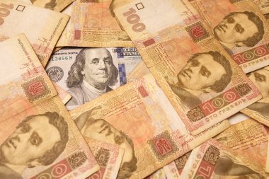 Amerikan Doları Ukrayna Grivnası ile serilmiş. Benjamin Franklin 'in portresi Ukraynalı banknotlar ile çevrilidir. Para arka planı