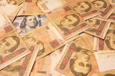 Amerikan Doları Ukrayna Grivnası ile serilmiş. Benjamin Franklin 'in portresi Ukraynalı banknotlar ile çevrilidir. Para arka planı