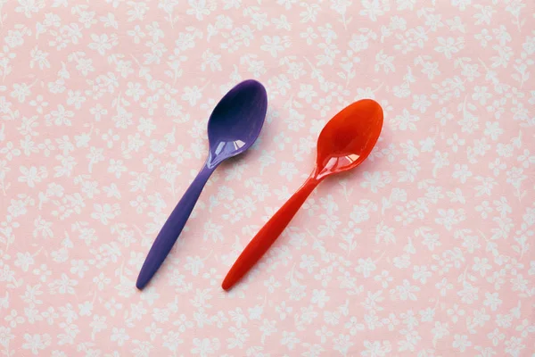 Dos cucharas de plástico para niños sobre un fondo de tela — Foto de Stock