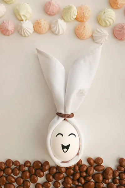 Ручної роботи великодній кролик з яєць і серветок тканини лежить навколо цукерок — стокове фото