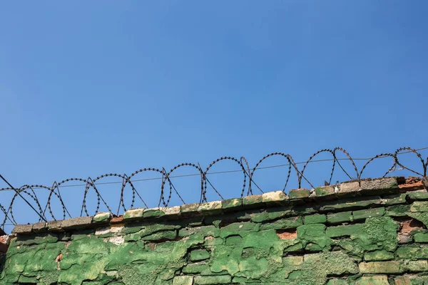 Betonnen muur, tegen de achtergrond van prikkeldraad, het concept van gevangenis, redding, Vluchteling, eenzaam, ruimte voor tekst — Stockfoto