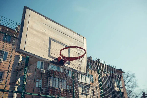 Aro de baloncesto con tablero en el distrito residencial para el juego de baloncesto callejero, deportes al aire libre y recreación, entorno urbano, imagen retro tonificada — Foto de Stock