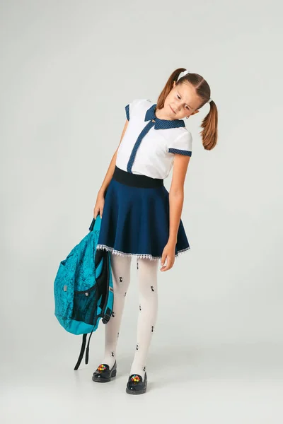 Okul üniforması ağır bir sırt çantası tutan liseli. Öğrenci aksesuarlarının ağırlama sorunu — Stok fotoğraf