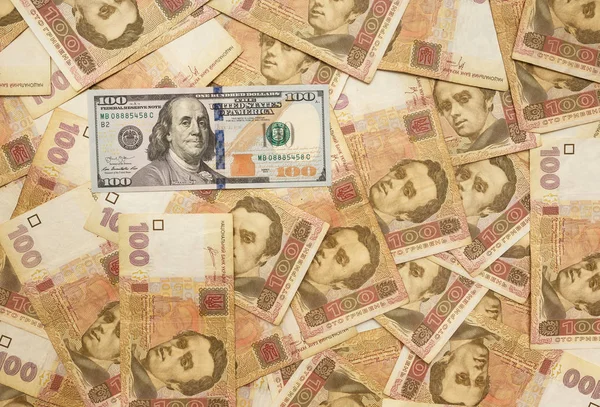 Американский доллар усыпан украинской гривной. Доллар среди гривен. Деньги фон — стоковое фото