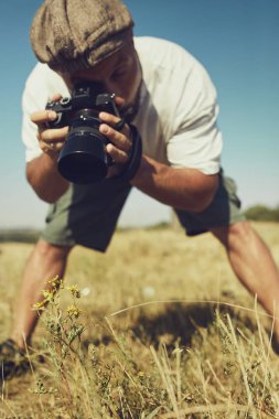 Mizahi bir konsept. Çok duygusal bir fotoğrafçı yerde bir şeyin fotoğraflarını çeker. Yüzünde sürpriz duygusu