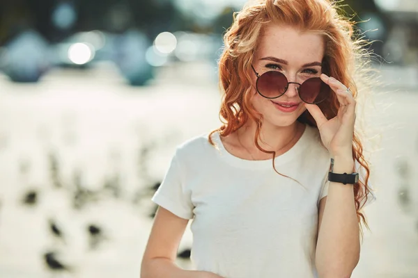 거리에서 재미를 가진 아름다운 빨간 머리 소녀. 소녀들은 아름다운 모습, 흰색 티셔츠와 선글라스와 청바지를 가지고 — 스톡 사진