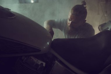 Garajında bir motosiklet tamir sakallı yakışıklı acımasız adam