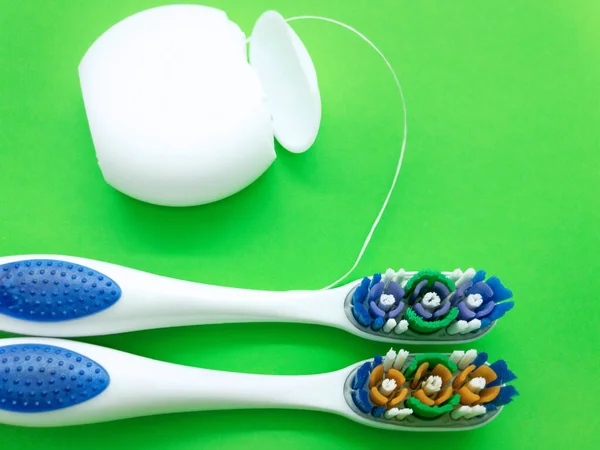 Cepillos Dientes Hilo Dental Aislados Sobre Fondo Verde Composición Cepillos — Foto de Stock