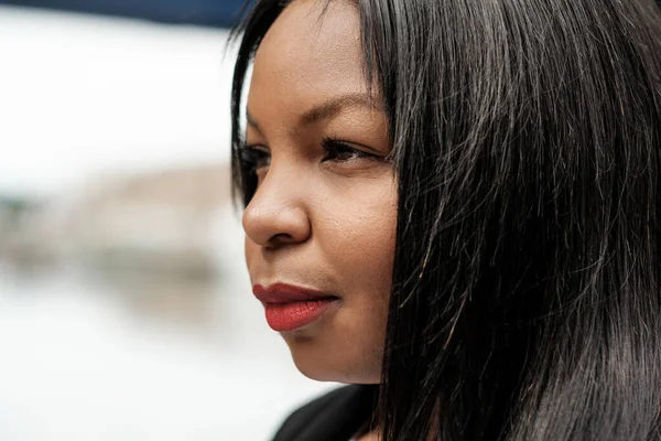 Kırmızı ruj sürmüş, profesyonellik, güven ve kurumsal bir ortamda amaç sahibi bir iş kadınının yakın plan profil görüntüsü.