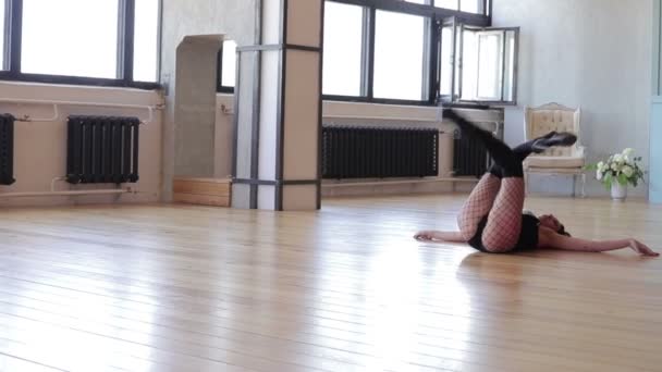 Молода жінка в незадоволеному одязі танцює на підлозі — стокове відео