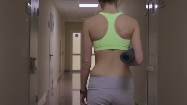 Femme sportive marchant dans le couloir — Video