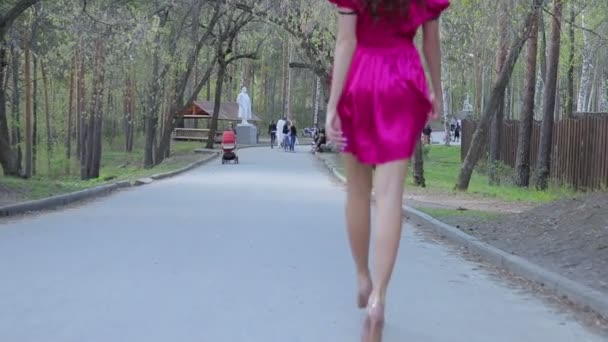 Безликая женщина, гуляющая в парке — стоковое видео