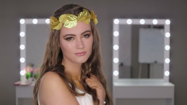 Frau mit Blättern im Haar blickt in die Kamera — Stockvideo