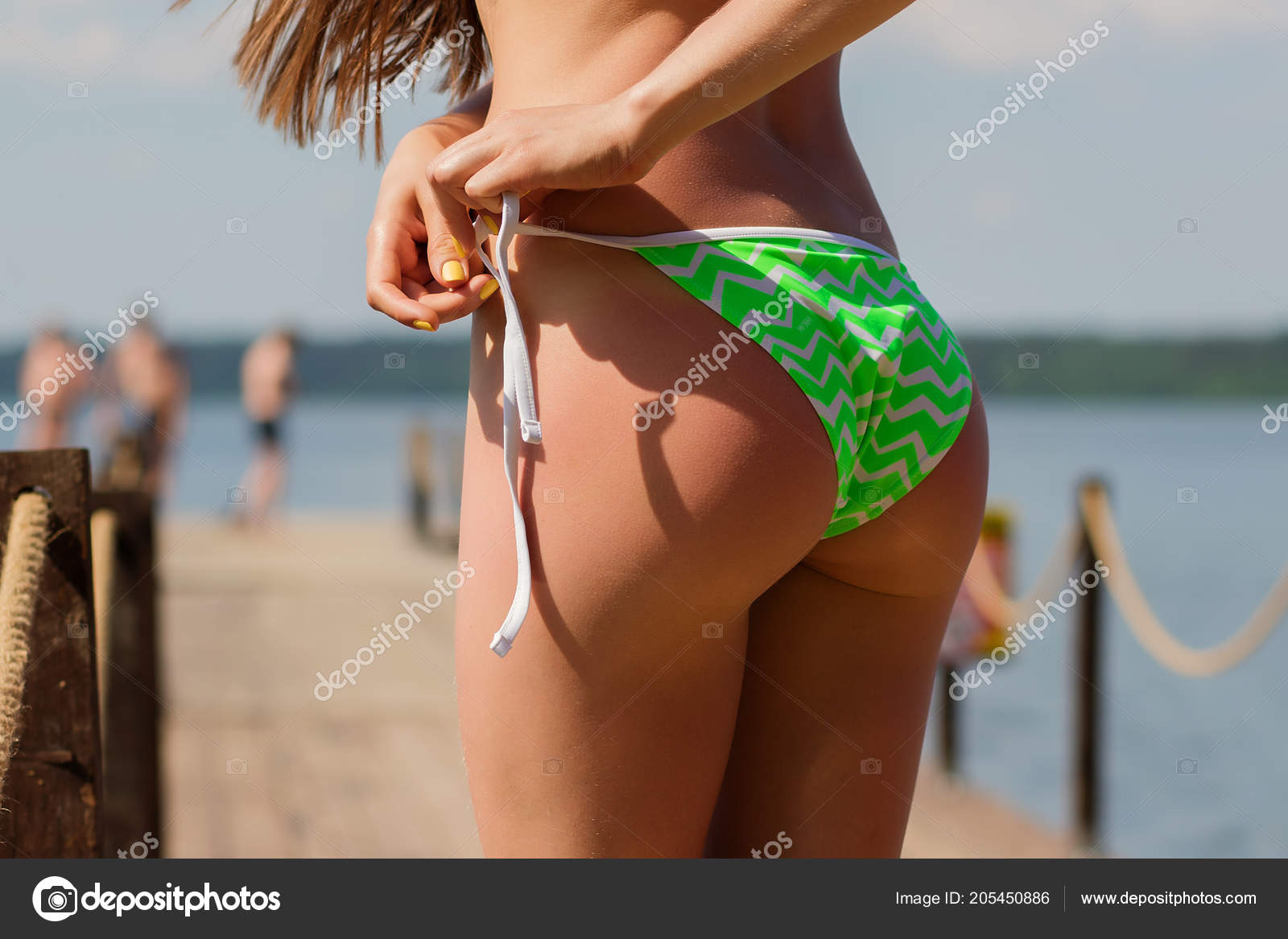 Sexy female adjusting bikini bottom Stock Photo by ©3kstudio 205450886